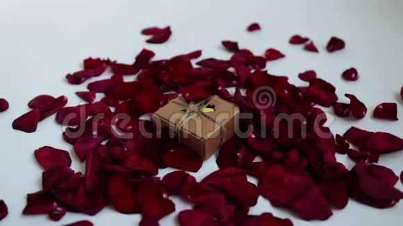 以玫瑰花瓣为背景的原始包装节日礼物视频的预览图