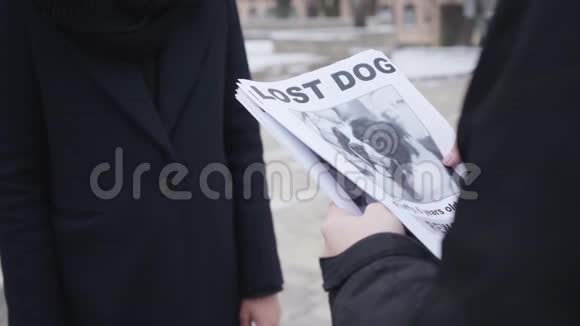 为无法辨认的女人提供失踪狗广告的白种人男性双手特写有人在寻找他们丢失的宠物视频的预览图