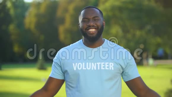 兴奋的非洲男性志愿者t恤展示力量姿态捐赠团结视频的预览图