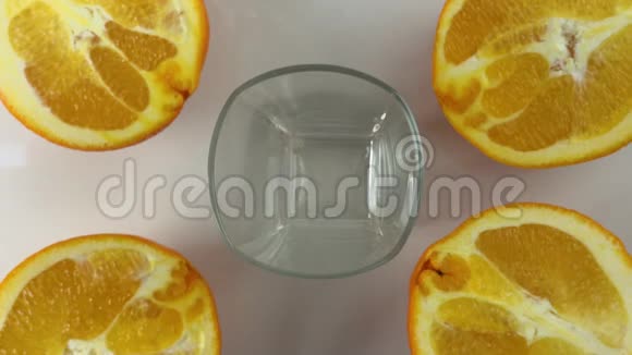新榨的橙汁倒在桌子上的一个杯子里旁边放着几片橘子令人振奋的黄色视频的预览图