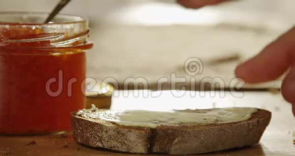红色鱼子酱在厨房的木桌上用银色勺子撒在一片黑面包上红色史诗上用太阳花拍摄视频的预览图