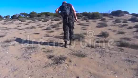 孤独疲惫的游客走在沙漠边视频的预览图