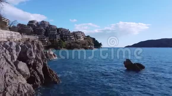 一架无人机飞在群山之间沿着酒店前的海岸视频的预览图