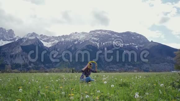 年轻女子在山上背景下尝试蒲公英花环总计划风景山水景观视频的预览图