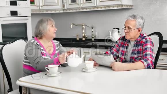 中年夫妇在舒适的公寓里一起喝茶享受交谈视频的预览图