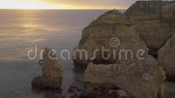 葡萄牙的PontadaPiedade海悬崖日出时船在拉各斯经过视频的预览图