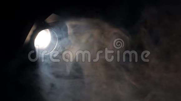烟雾在黑暗中闪烁着明亮的探照灯视频的预览图
