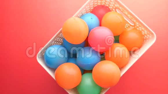 红色背景彩色塑料球的俯视图视频的预览图