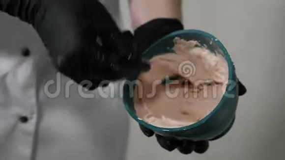 在美容院特写镜头美容师把面膜和铲子混合在碗里混合面膜的过程视频的预览图