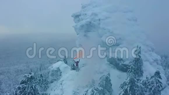 鸟瞰手持橙色信号烟的人站在山顶视频的预览图