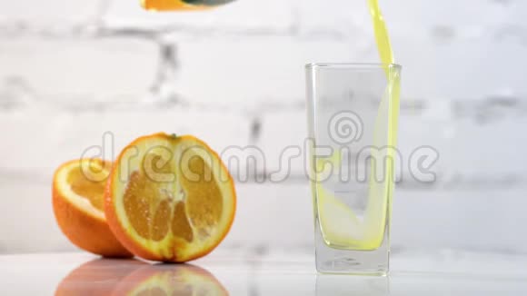 鲜榨的橙汁倒在桌子上的玻璃杯里旁边放着几片橘子新鲜黄色饮料视频的预览图