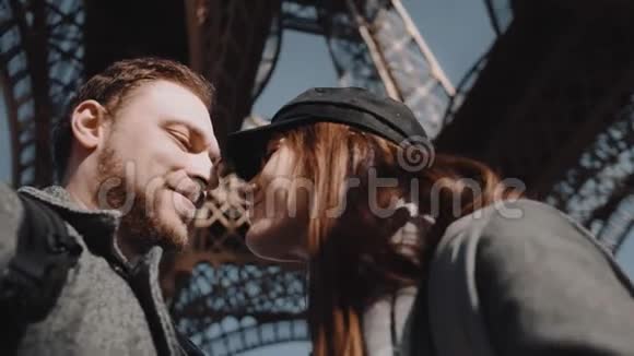 特写低角度幸福微笑浪漫情侣接吻相视巴黎埃菲尔铁塔下慢动作视频的预览图