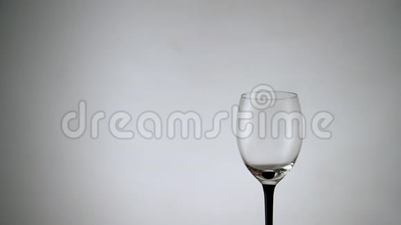 将红酒倒入白色背景的玻璃杯中在浅色背景下盛满酒精饮料的酒杯视频的预览图