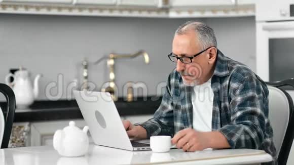 自信衰老的白发人专注地看着电脑屏幕上的文字视频的预览图
