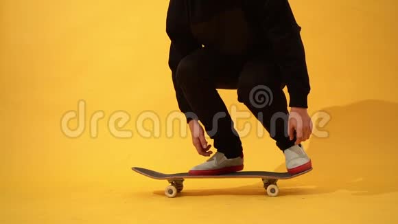 滑板运动员在演播室表演滑板技巧踢翻运动员在黄色背景下练习特技跳跃准备视频的预览图