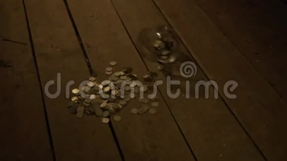 一个玻璃罐子的硬币落在乡村的木地板上玻璃坏了硬币倒了贫困的概念视频的预览图