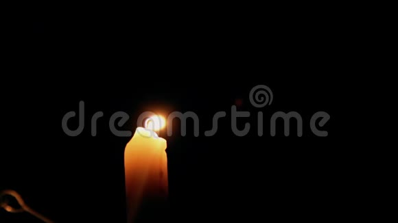 一支美丽的蜡烛在黑暗的房间里燃烧一支温暖的黄色蜡烛在黑暗中静静地燃烧视频的预览图