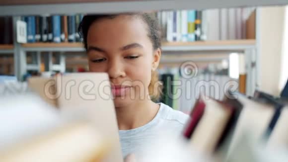 非洲裔美国青少年在学校图书馆选书的肖像视频的预览图