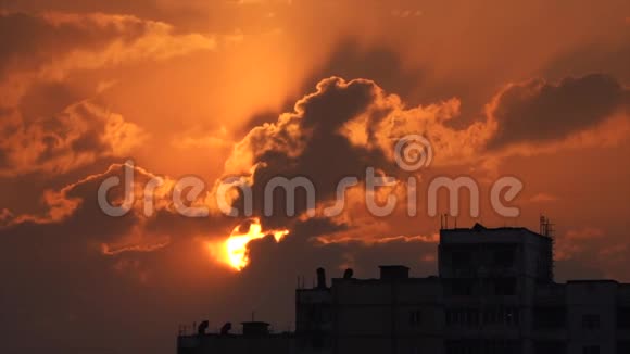 城市轮廓与戏剧性的日落橙色云和太阳盘视频的预览图