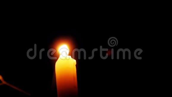 一支美丽的蜡烛在黑暗的房间里燃烧一支温暖的黄色蜡烛在黑暗中静静地燃烧视频的预览图
