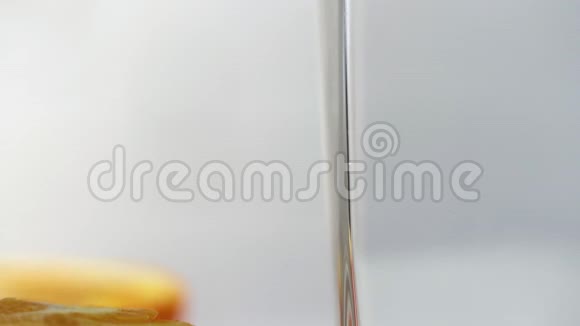 鲜榨的橙汁倒在桌子上的玻璃杯里旁边放着几片橘子新鲜黄色饮料视频的预览图