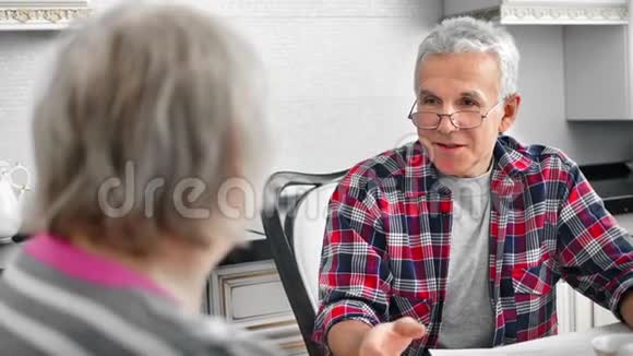 热情的老年男性在厨房与成熟的妻子交谈有积极的情绪视频的预览图