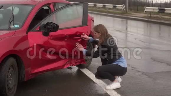 雨中一个年轻女孩坐在路上一辆破车旁她很害怕视频的预览图