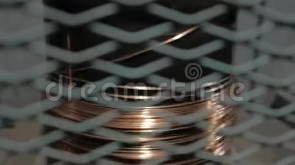 在旋转线圈上缠绕铜电缆通过金属格栅查看视频的预览图