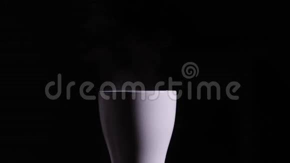 用沸水从白色的杯子里蒸出来一滴蒸汽从一杯热咖啡中涌出完全是黑色背景你可以视频的预览图