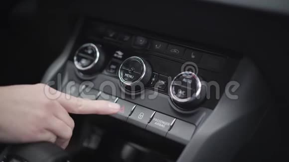 特写女性白种人手按紧急灯按钮在汽车仪表板上无法辨认的年轻女子视频的预览图