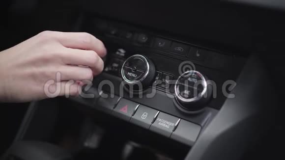 女性白种人的手转动和按下汽车仪表板上的按钮年轻的不认得的女人在检查汽车视频的预览图
