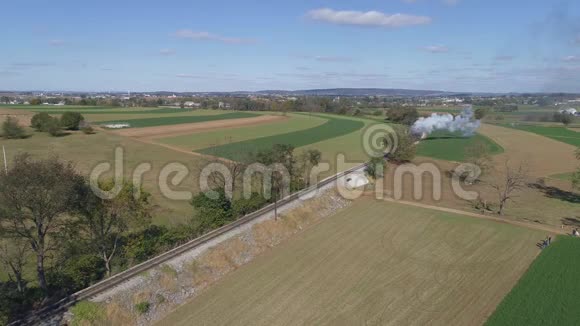 一列即将到来的蒸汽火车在沿着乡村行驶时吹烟和蒸汽视频的预览图
