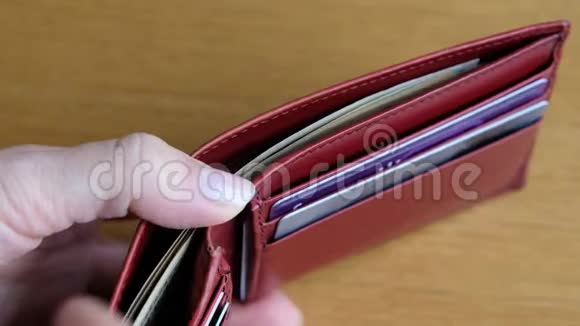 女人拿着钱打开红色钱包视频的预览图