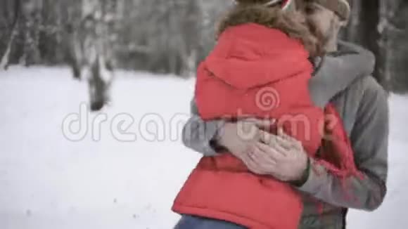 恋爱中的男孩和女孩在冬天的森林里玩雪年轻人脸上的幸福和微笑视频的预览图