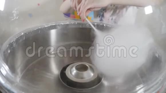 女性手摇棉花糖在糖果牙线机做糖果糖白色仙女糖果牙线机视频的预览图