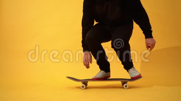滑板运动员在画室表演滑板把戏奥利在黄色背景下练习跳跃的运动员特技镜头视频的预览图