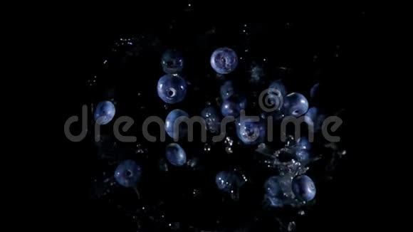 大蓝莓正在黑色背景下随着水的飞溅而飞视频的预览图
