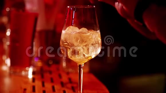 一个经典的酒保把汽酒从一个高杯倒入一个鸡尾酒杯在一个时尚的酒吧内部视频的预览图