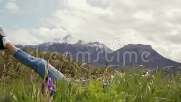 快乐的女人躺在高山草地上微笑着站起来摄像机旋转视频的预览图