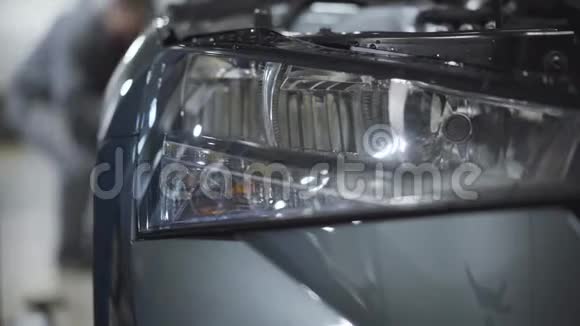 汽车前照灯的特写与模糊的汽车机械紧固螺丝在车轮上维修或调整服务车辆视频的预览图