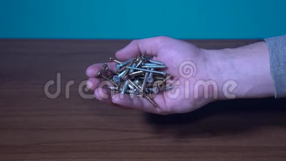 一个人手握金属螺丝和螺栓视频的预览图