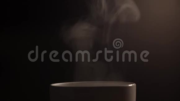 用沸水从白色的杯子里蒸出来一滴蒸汽从一杯热咖啡中涌出完全是黑色背景你可以视频的预览图
