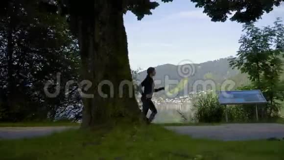跟踪镜头女腿穿着运动鞋在湖边和山上跑步清晨在公园里训练女孩慢跑视频的预览图