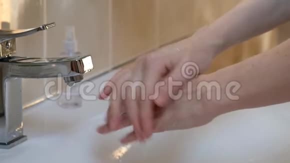 女人用泡沫在洗手盆洗手从病毒中清洁皮肤电晕病毒的贫血视频的预览图