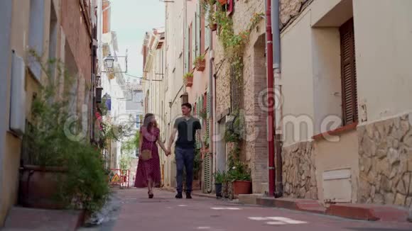 情侣们牵着手微笑着走在法国安蒂布斯的老城遥远的计划视频的预览图