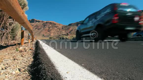 未被识别的黑色越野交叉车沿着沙漠中的一条山地沥青路行驶明亮的道路标记视频的预览图