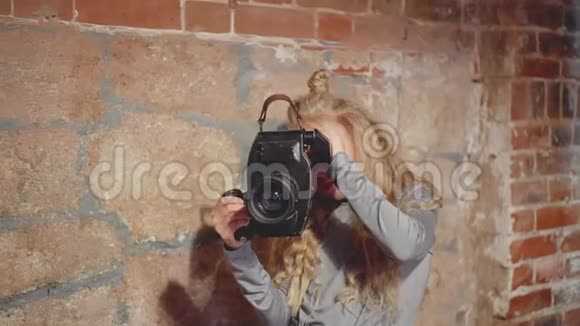 年轻的女录像操作员手持黑色摄像机视频的预览图