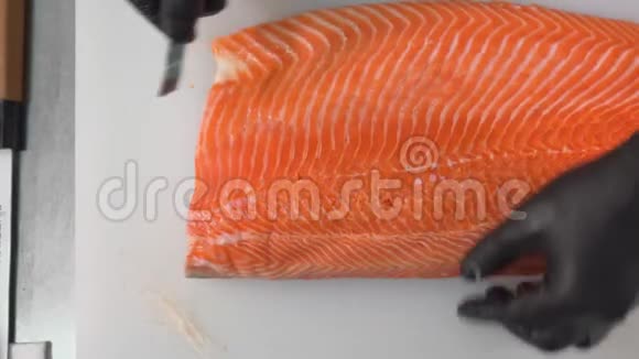 厨师用镊子把鲑鱼片上的骨头拔出来视频的预览图