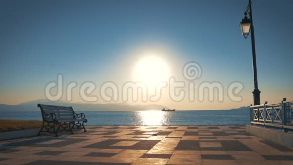 长凳和一盏灯在海湾和背景大海和太阳面对相机在黎明视频的预览图