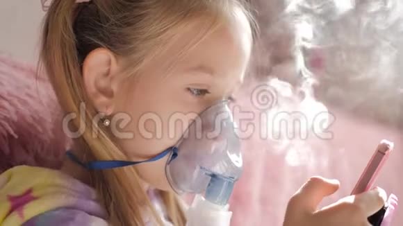 小女孩在家拿着吸入器面罩生病的孩子通过雾化器呼吸婴儿使用治疗哮喘或视频的预览图